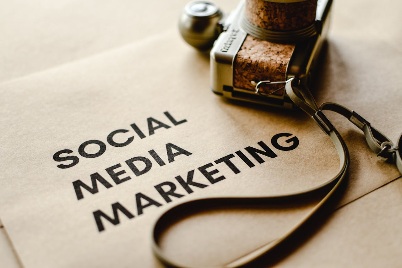 about-us Close-up of a camera placed on brown paper with 'Social Media Marketing' text, emphasizing digital marketing themes.