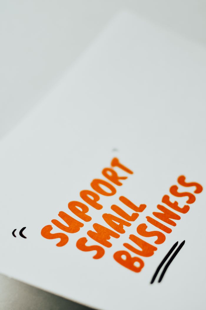 services-04 Close-up of a 'Support Small Business' message in orange text on a white paper.